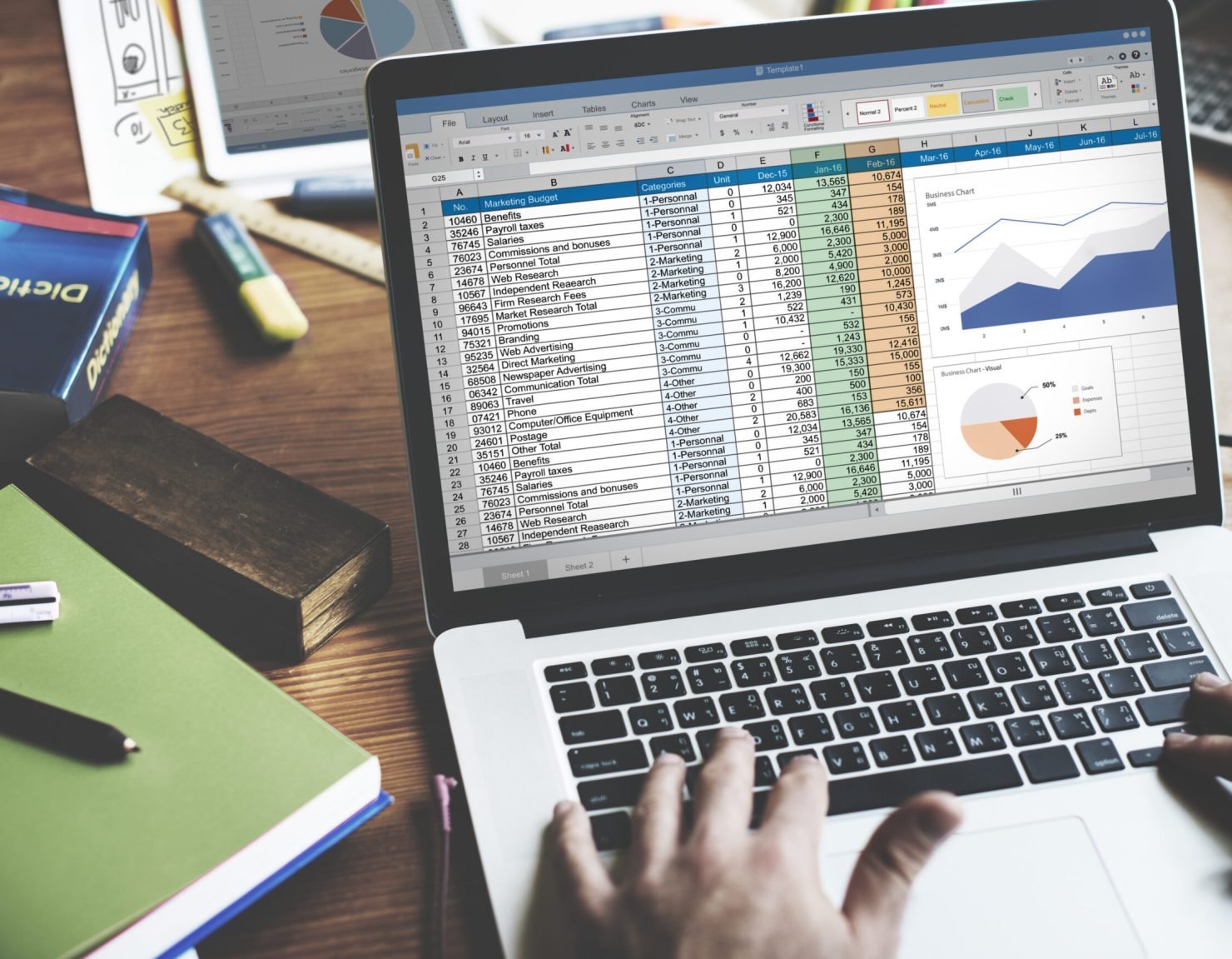 Closeup of hands using computer laptop with screen showing analysis data