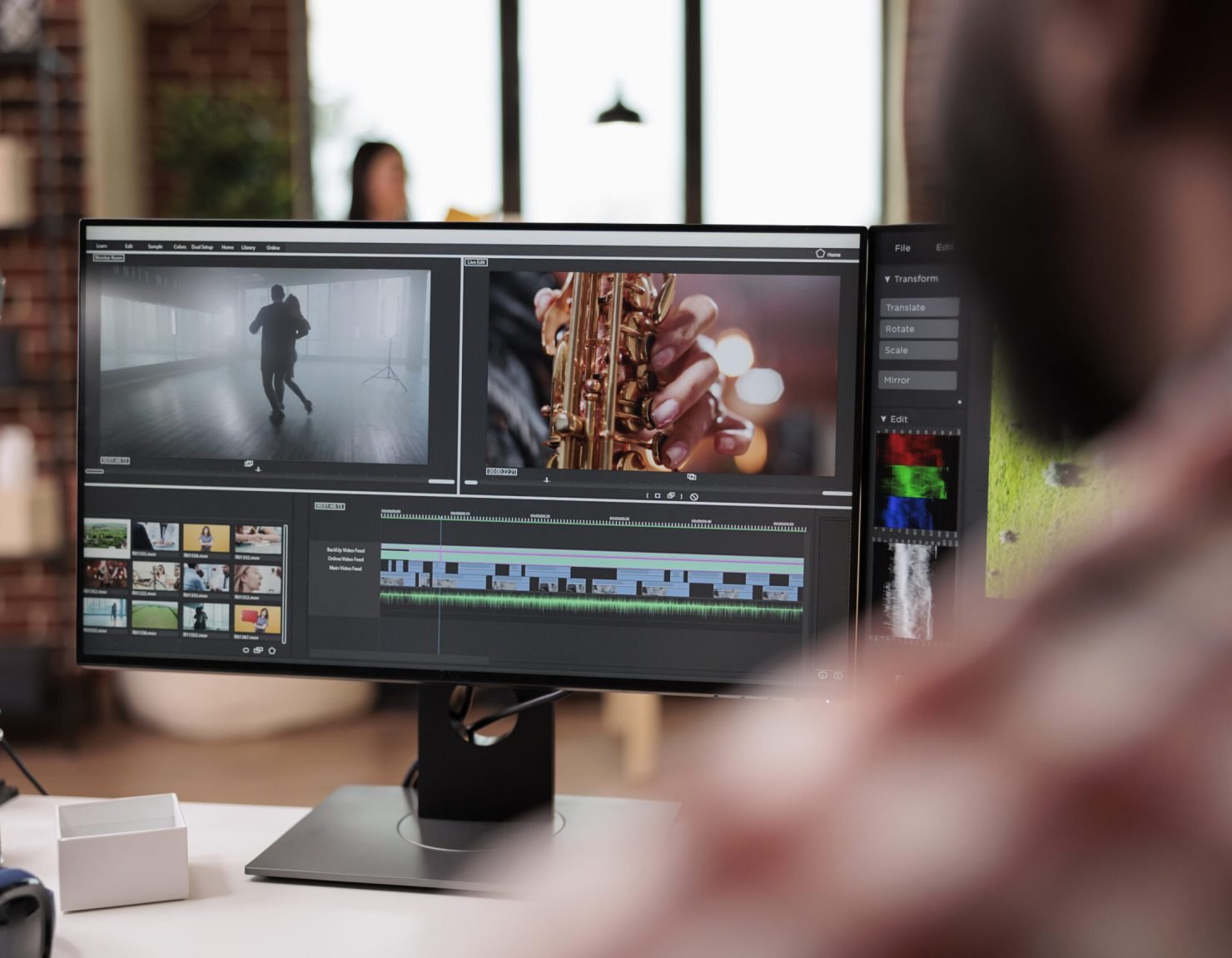 Male videographer editing video montage on post production software, working on computer. Creating movie content with color grading, edit creative multimedia film footage on app.